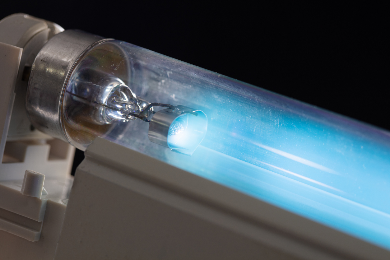 Close-up of a UV light tube glowing blue, commonly used in UV air purifier installations.