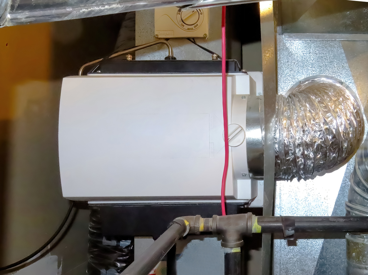 A home HVAC humidifier attached to the return duct with a bypass connection to the supply hot air duct.